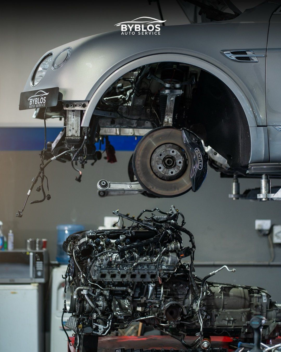 A Bentley with its front corner and engine bay opened up for repair